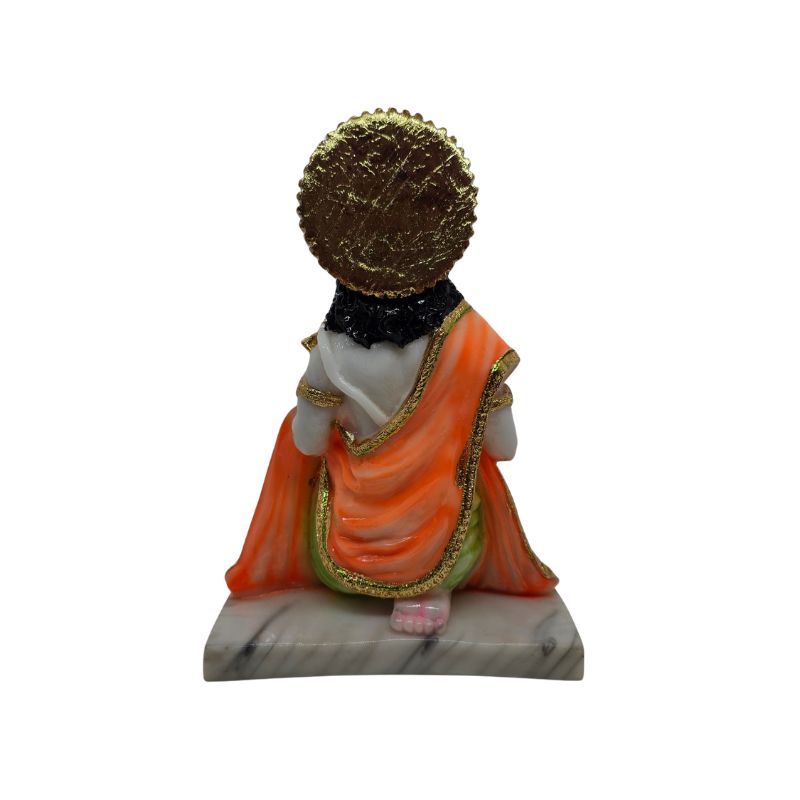 Achteraanzicht van Hanuman murti met ronde gouden halo en oranje draperie.